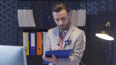 Elegant-and-uniquely-styled-businessman-works-in-the-office,-taking-notes,-creating-plans-and-schedules.