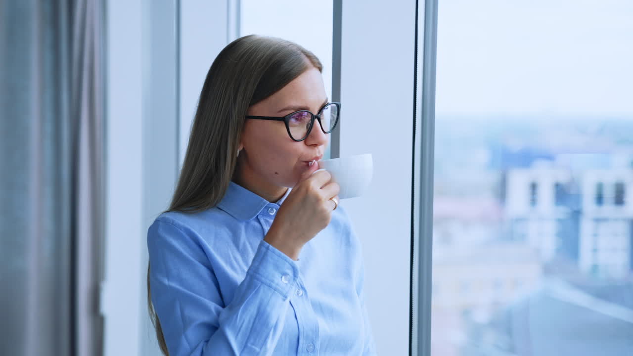 Donna d'affari che si gode una pausa caffè alla finestra