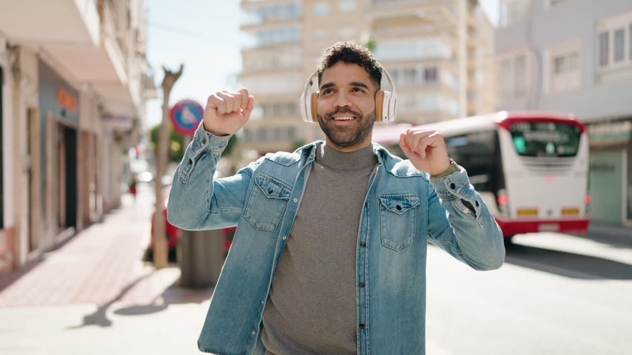 giovane arabo che sorride sicuro ascoltando la musica in strada