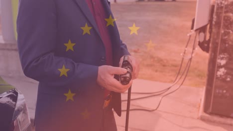 bandera de la unión europea sobre el hombre que conduce un coche eléctrico