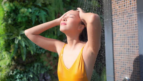 After-a-swim-in-the-resort-pool,-a-very-attractive-woman-washes-off-the-chlorine-from-the-pool