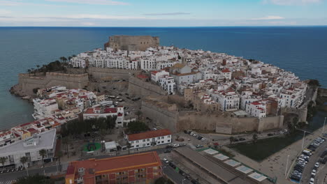 high drone establishing of peniscola port and castle hill with boats docked in calm waters