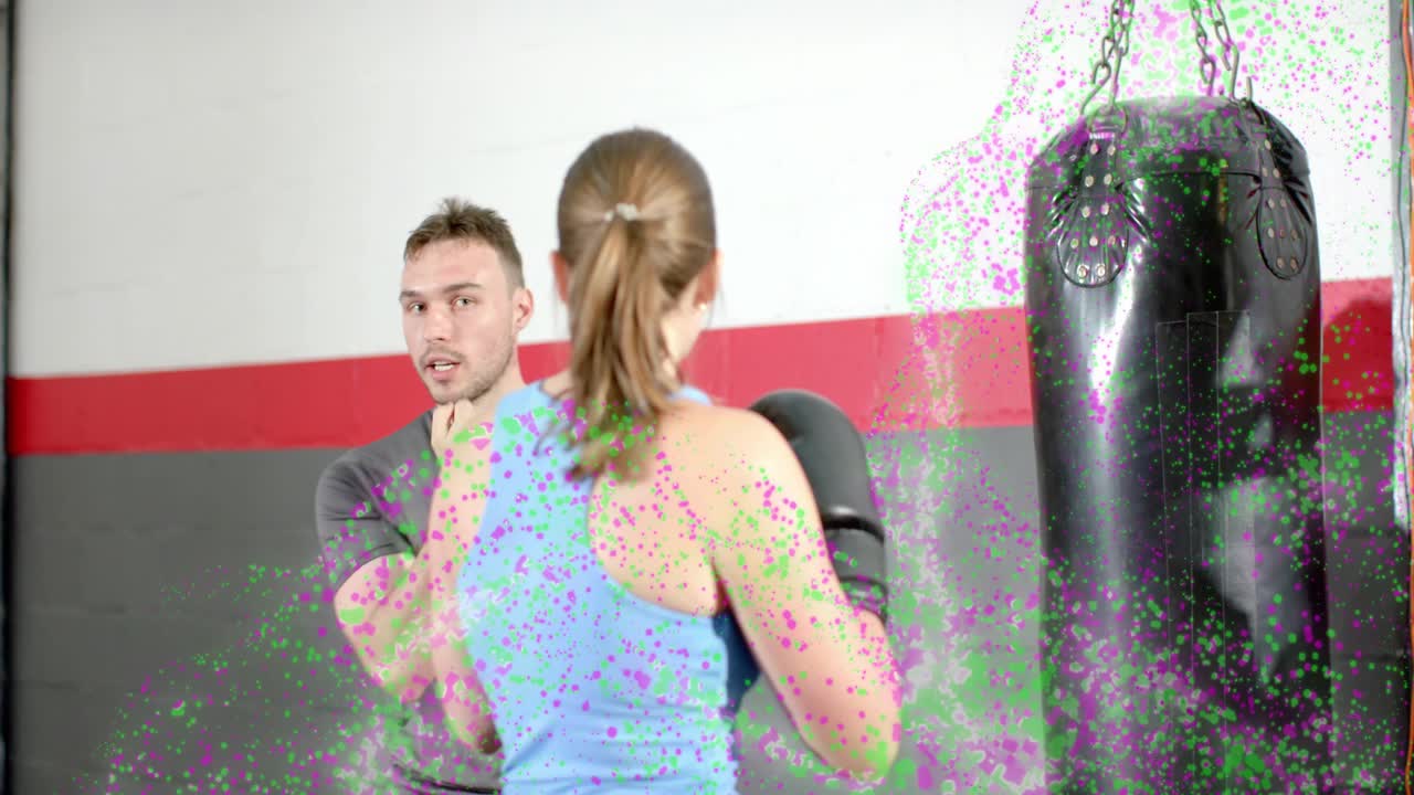 Trainer speaking, guiding trainee fixing guard and striking heavy bag, improving boxing form