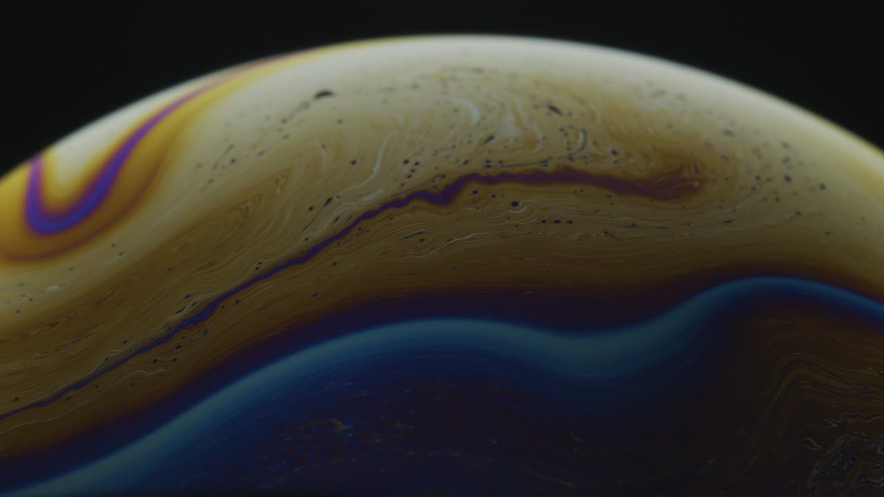 Closeup Macro Shot of Soap Bubble with Dark Yellow Line Streaks