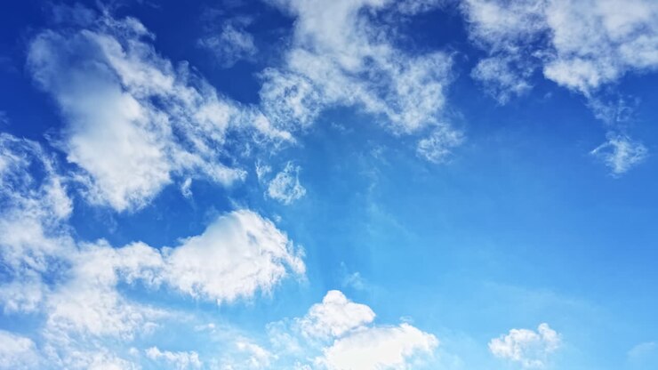 Bright blue sky adorned with fluffy clouds during a serene daytime, capturing the essence of peace and tranquility in nature's canvas