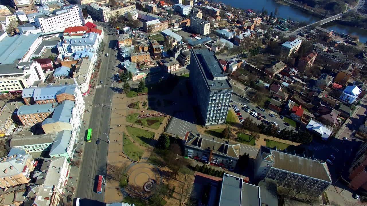 Ukrainian city downtown on sunny midday. Multiple buildings in the city centre near the river bank. Top view.
