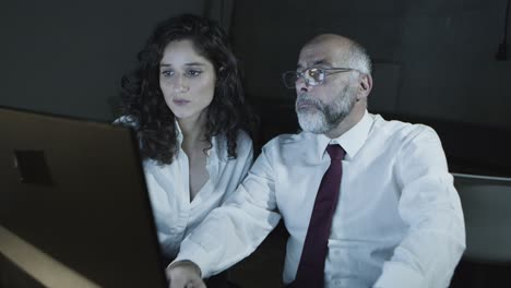 hombre de negocios apuntando a la computadora y hablando con una mujer de negocios