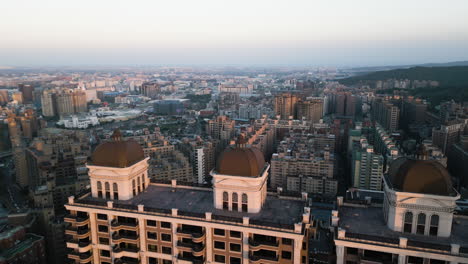 Sunrise-golden-hour-light-spreads-on-Luzhu-Taoyuan-Taiwan,-aerial-dolly