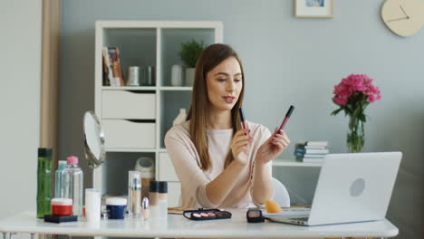 Pretty-Beauty-Blogger-Talking-About-Lip-Glosses-In-Front-Of-The-Laptop-Camera-At-Home