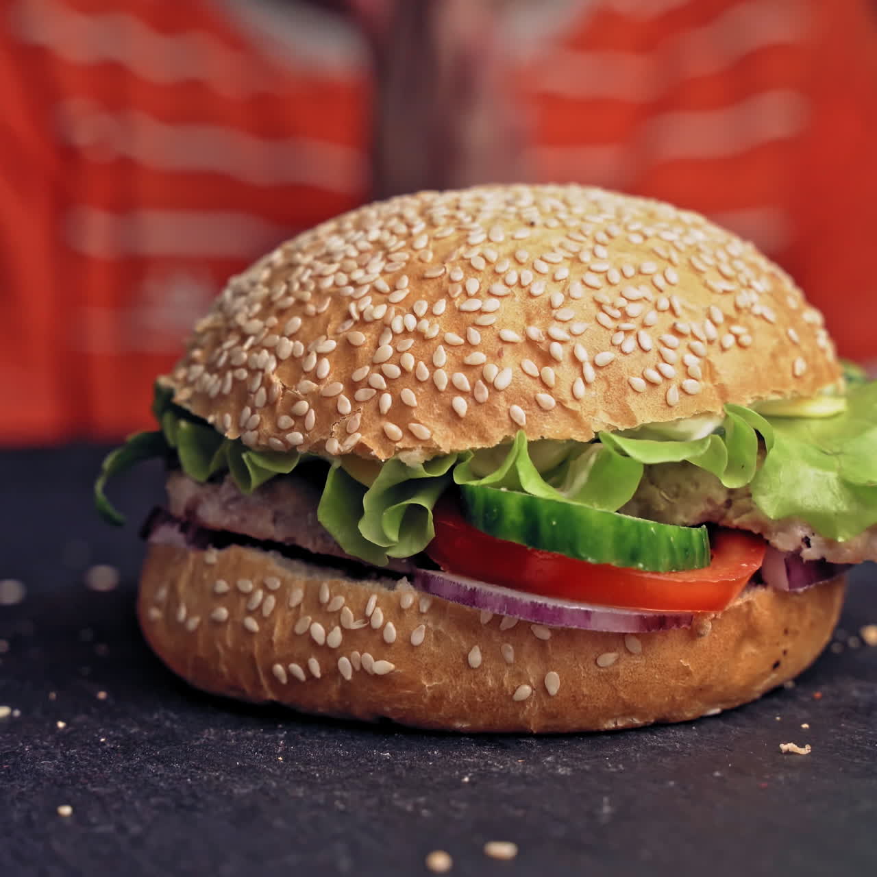 teenager hands take a tasty hamburger lying on the table close up. Delicious grilled burger