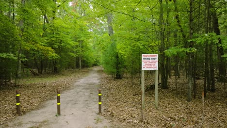 drone pulling back from hiking sign to reveal trailhead