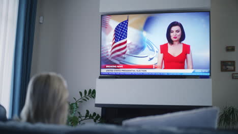 woman watching news about presidential election on tv