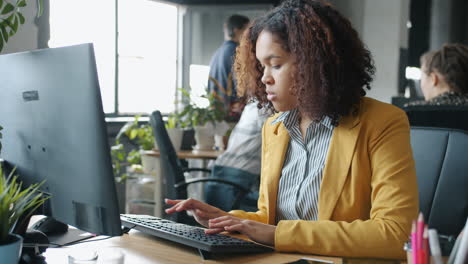 mujer trabajando en computadora en una oficina moderna