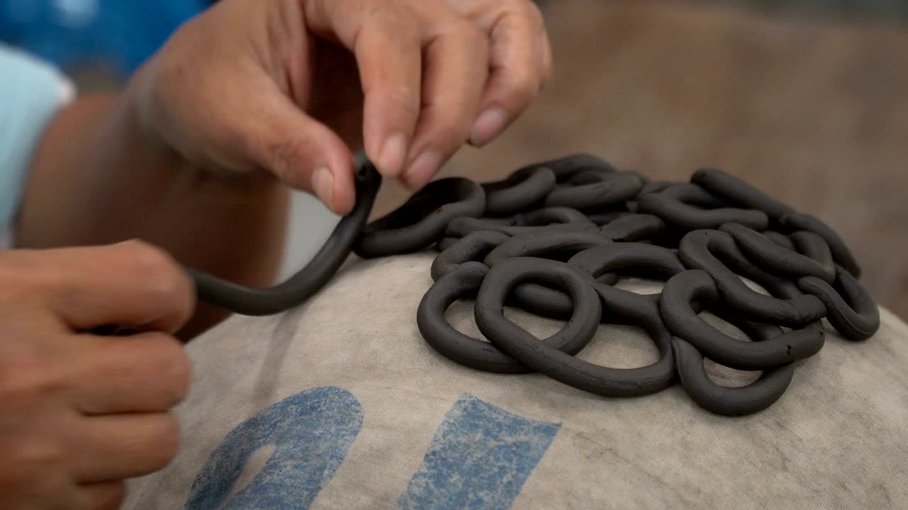 fabricación tradicional de cerámica, primer plano de las manos del alfarero dando forma a un cuenco en el hilado por arcilla