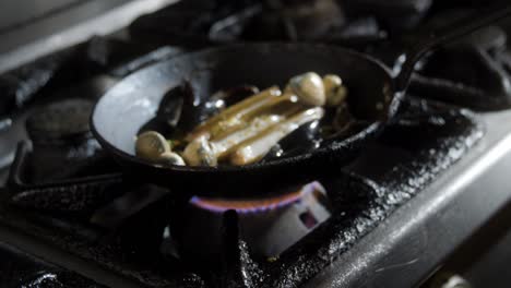 mussels and seafood cooking in pan with herbs