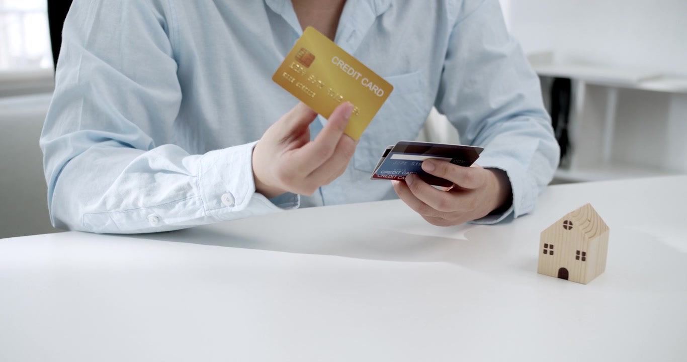 Giovane uomo seleziona attentamente una carta di credito pensata per le spese di manutenzione della casa, assicurazione e riparazioni, mostrando scelte finanziarie intelligenti