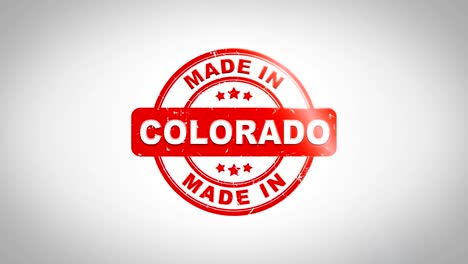 made in colorado signed stamping text wooden stamp animation. red ink on clean white paper surface background with green matte background included.