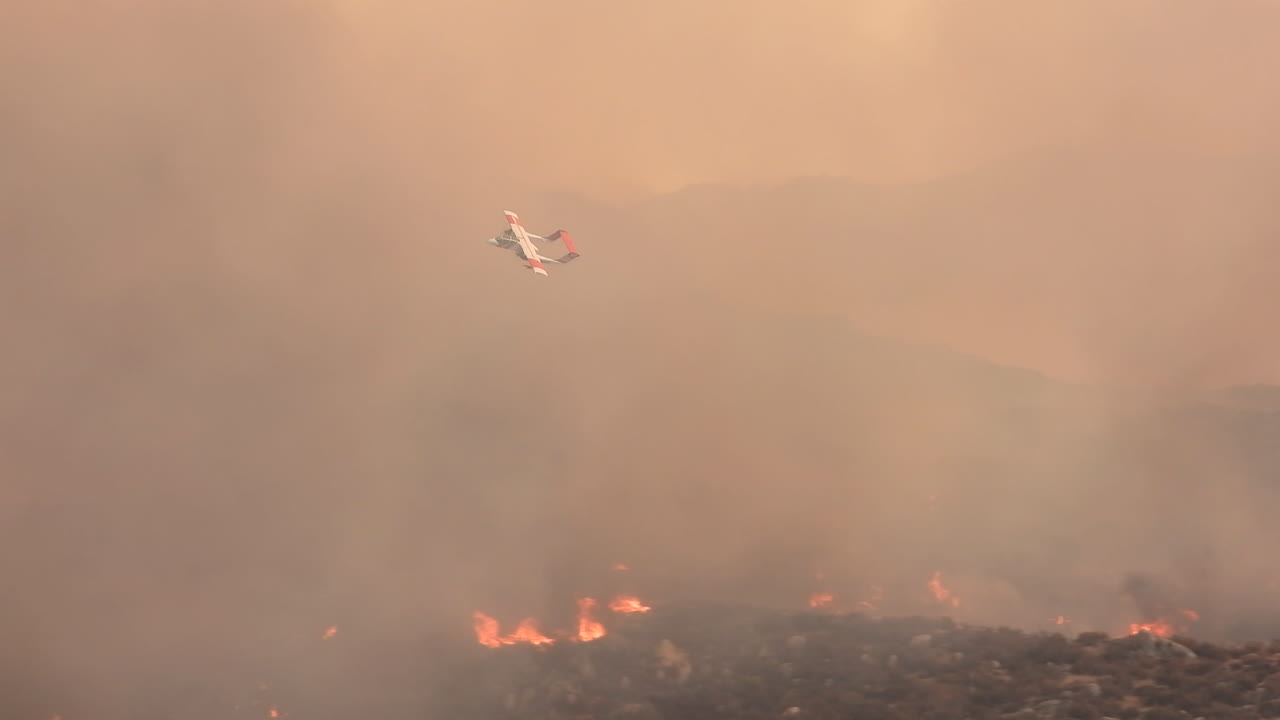 Avión de bomberos sobrevuela incendios forestales y humaredas en California, vista de seguimiento