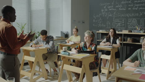 teacher giving a lecture to a diverse group of college students in a classroom