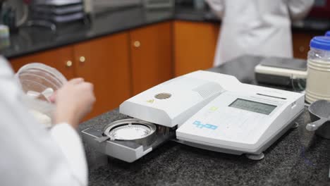 a sample of flour is added to a tray on a laboratory machine for testing the quality of flour