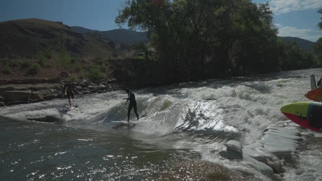 Early-morning-Colorado-river-surfer-surfing-Scout-wave-Salida-Buena-Vista-Denver-turns-to-left-and-right-stagnant-carves-back-in-forth-community-watching-beautiful-sunny-blue-bird-day-cinematic-slow