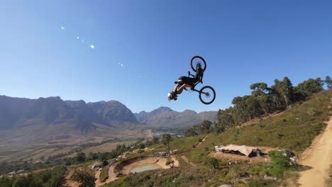 Extreme-mountain-biker-doing-a-backflip-during-Darkfest-in-Stellenbosch,-South-Africa