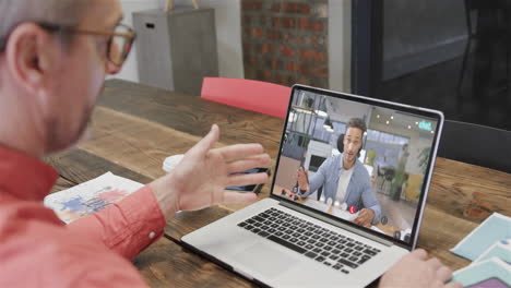 hombre de negocios caucásico en una videollamada con un colega caucásico en la pantalla