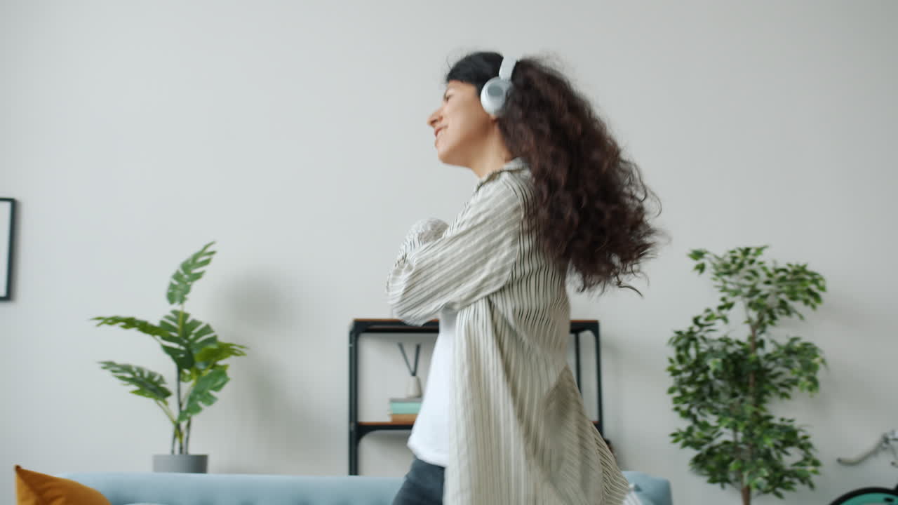 mujer bailando a la música en casa