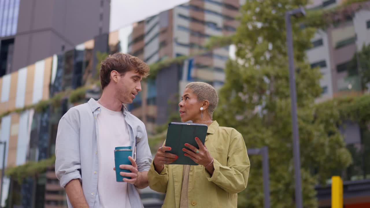 People talking outdoors while using a tablet