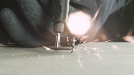 electric cutter cuts a screw stuck in the wood