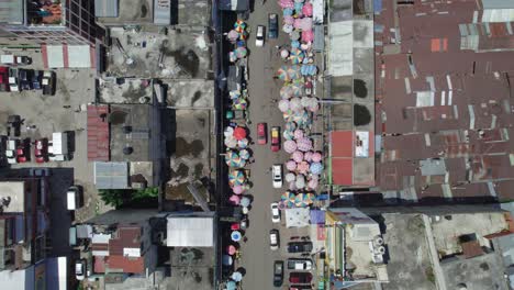 drone aerial footage of central american colonial street market during the day with usual foot and vehicle traffic