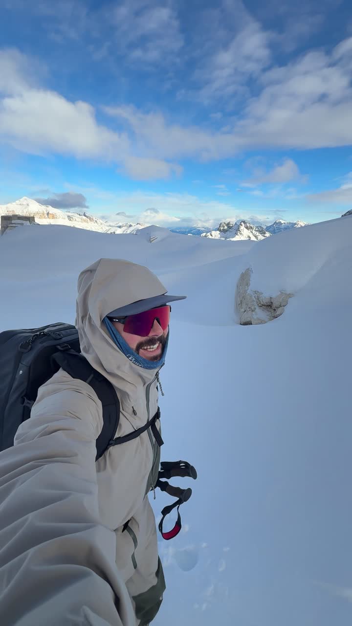 Una persona in tenuta invernale cammina in un paesaggio montano innevato - Inquadratura in soggettiva