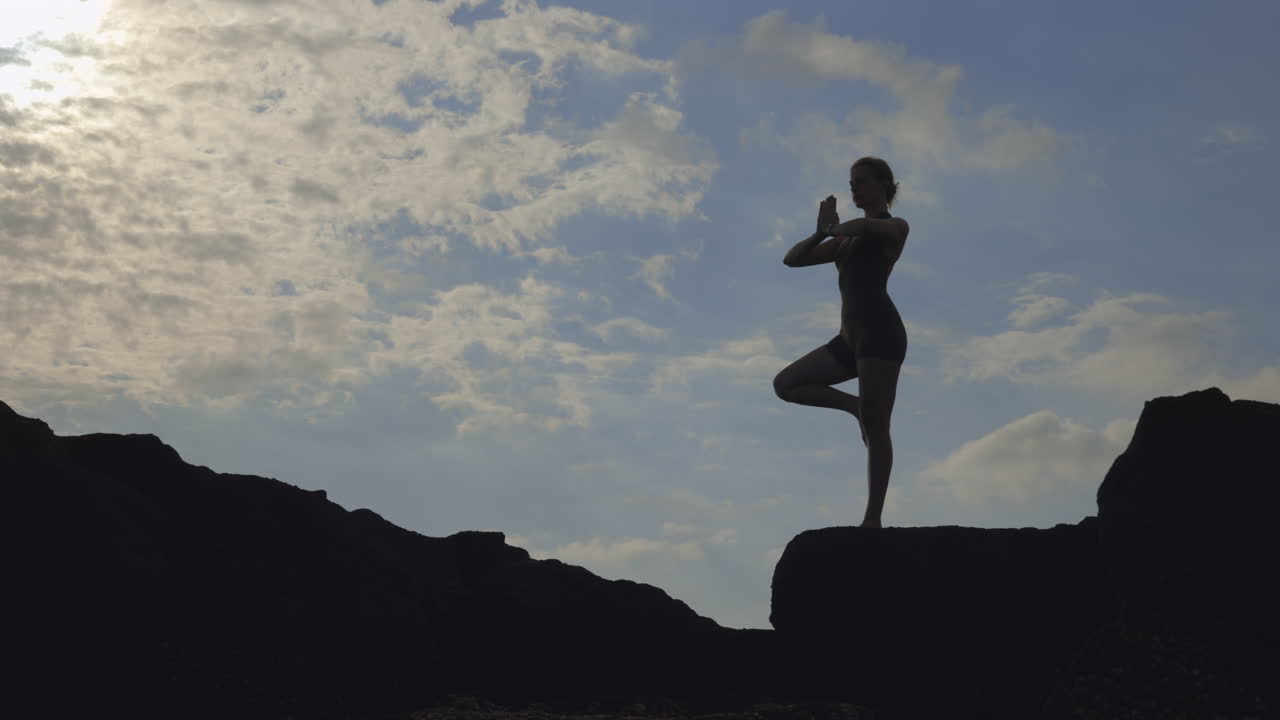 해가 지면 요가를 연습하는 여자