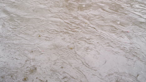 Las-Gotas-De-Lluvia-Golpean-Un-Río-Opaco-Y-Arremolinado