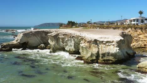 rugged white cliffs eroded from ocean waves along a rocky coastline - aerial parallax view in slow motion