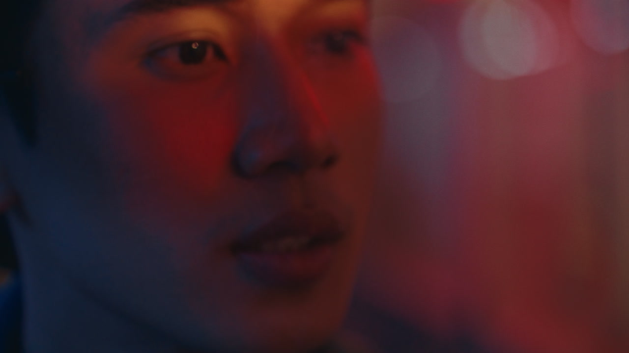 Close-up of a person's face in vibrant lighting