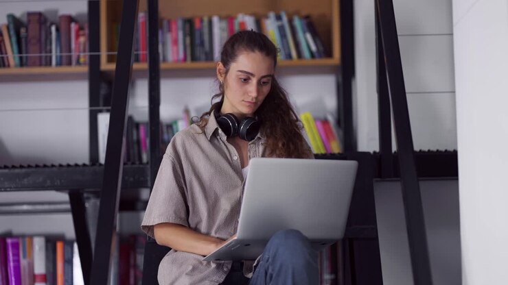 Affascinante studentessa che fa ricerche per un progetto startup usando il laptop