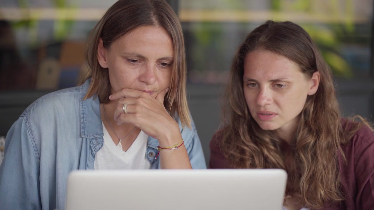 Duas mulheres colaborando em um notebook em um café