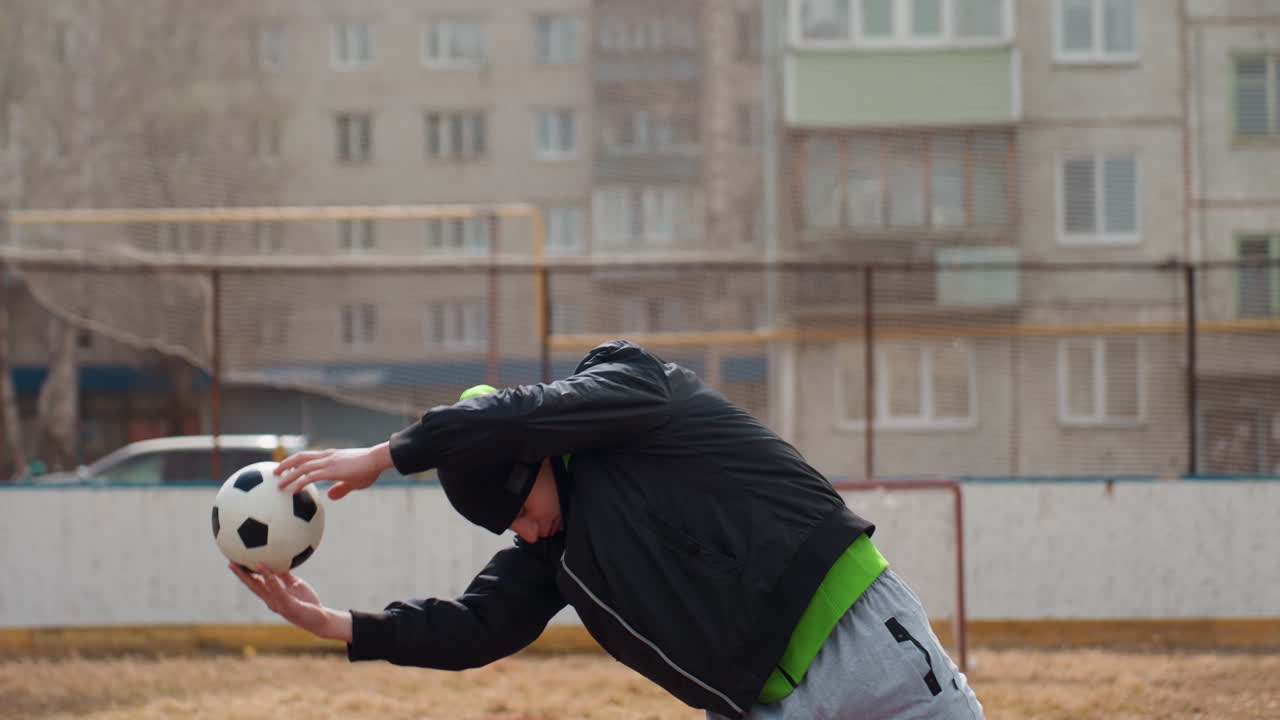 남자 운동선수가 탁 트인 경기장에서 공으로 훈련하고, 경쟁자는 도시 훈련장에서 빠른 반응 훈련을 실시하며, 개인은 도시 야외 환경에서 강렬한 축구공 기동 연습을 하고 있어요.