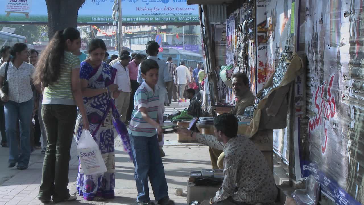 un niño quiere comprar algo de un vendedor ambulante y su madre se lo compra