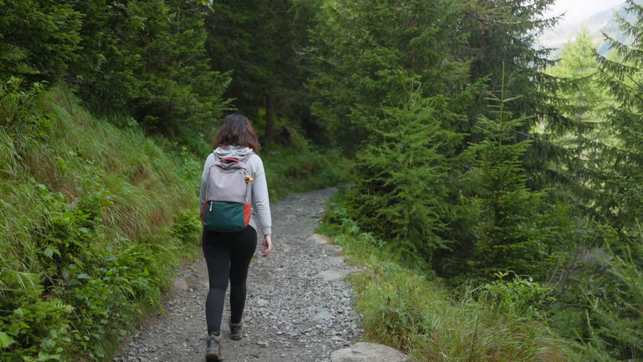 mujeres excursionistas caminando por un sendero de montaña en valmalenco, italia