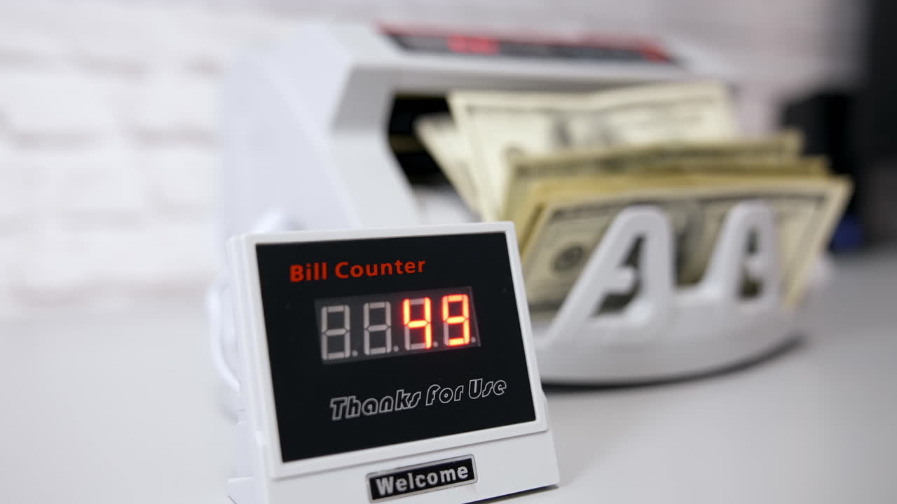 Electronic device showing the amount of money. Equipment for counting money. Money are counted in a calculating machine. Automatic equipment for banking financial transactions.