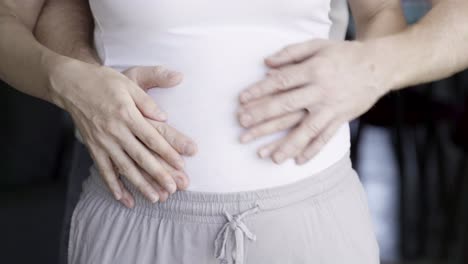 Closeup-shot-of-young-couple-touching-tummy