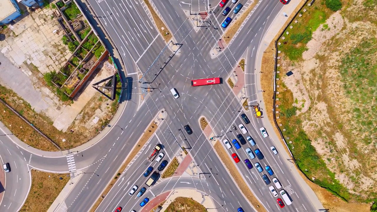 Large road intersection with moving cars, Bratislava, Slovakia. High angle drone shot of automobile traffic navigating white lane markings on asphalt.