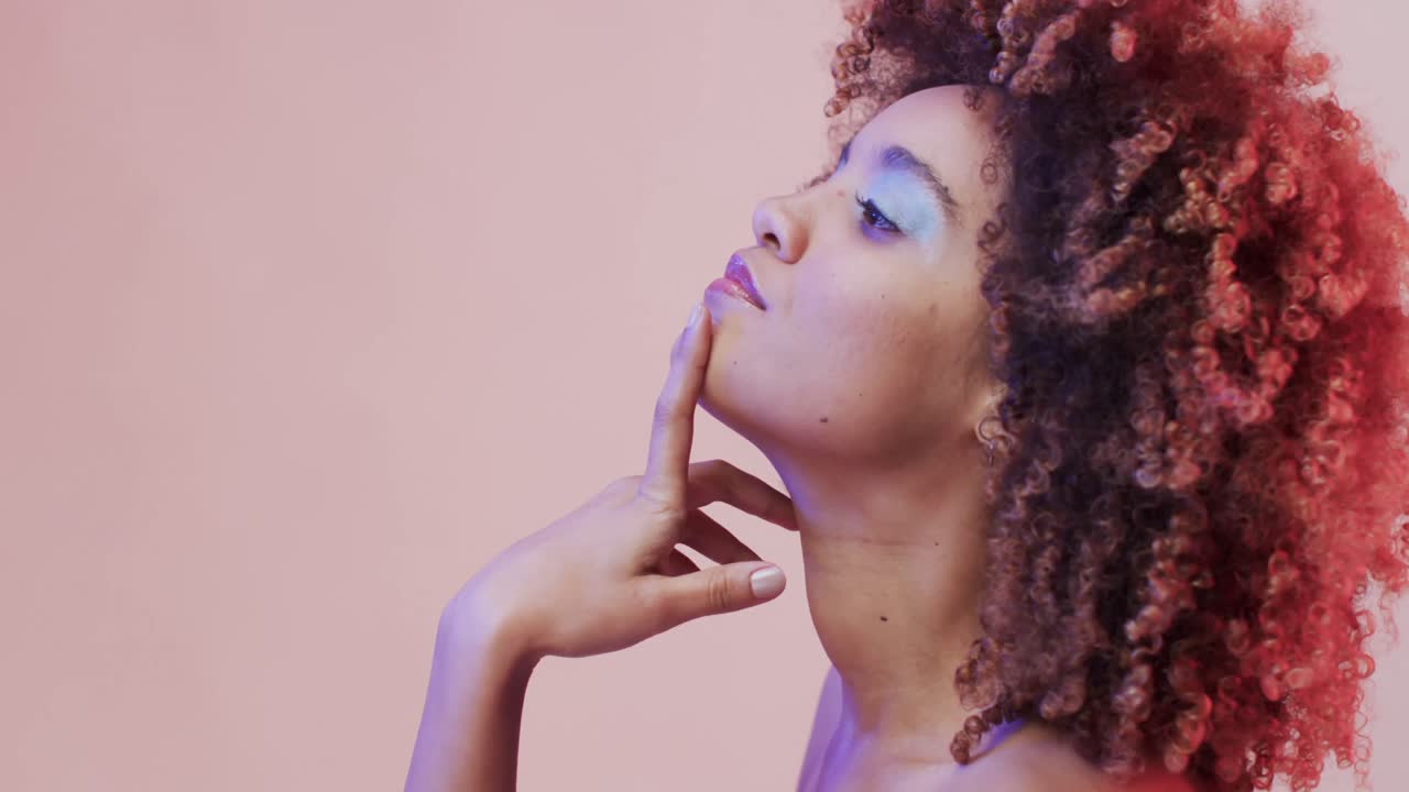 mujer biracial con cabello oscuro en luz azul y rosa con espacio de copia, cámara lenta