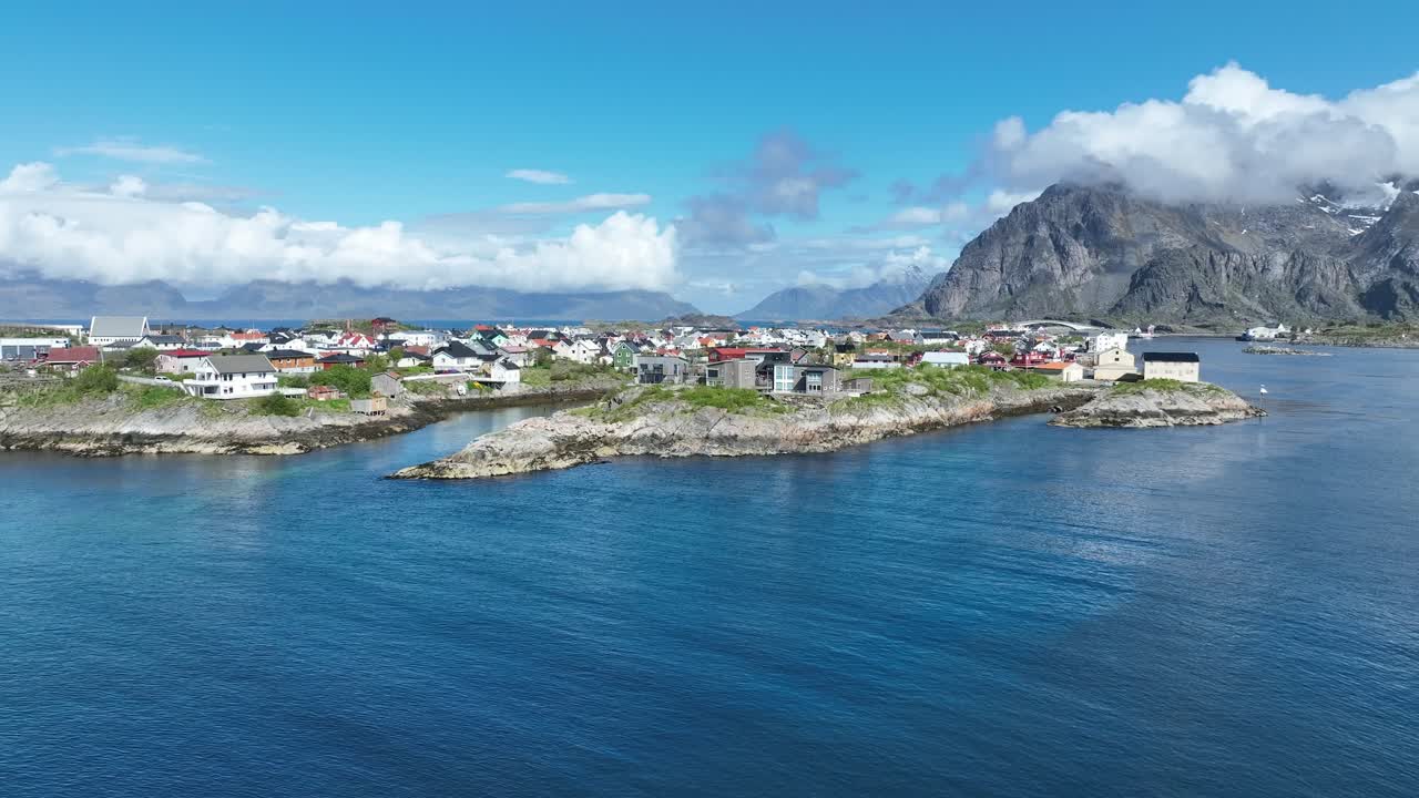 Henningsvaer'de çimen ve funda adacığı; köy, sahil ve Festvagtinden'e doğru yükselen manzara