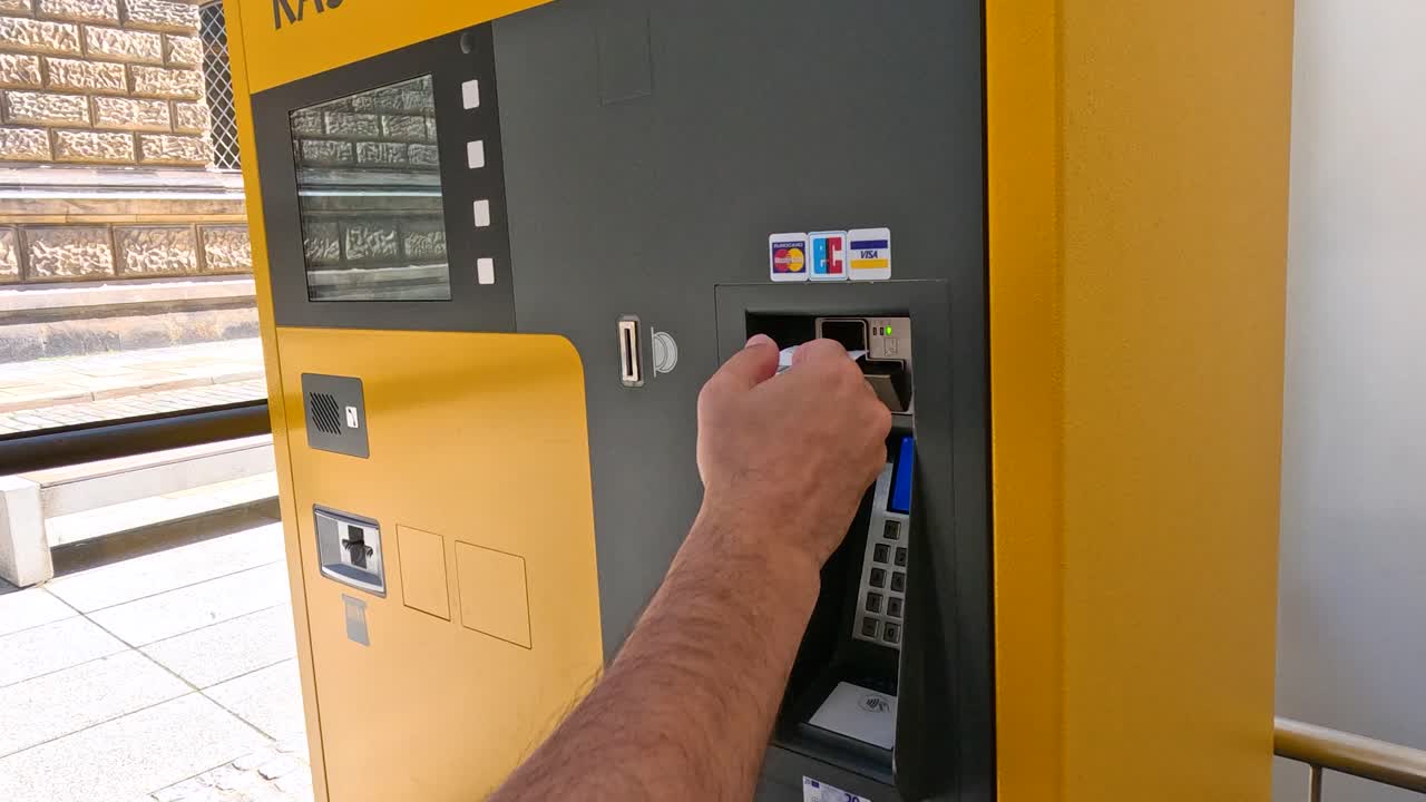 Man inserts payment card into yellow outdoor ticket machine in Dresden, Germany, during daylight