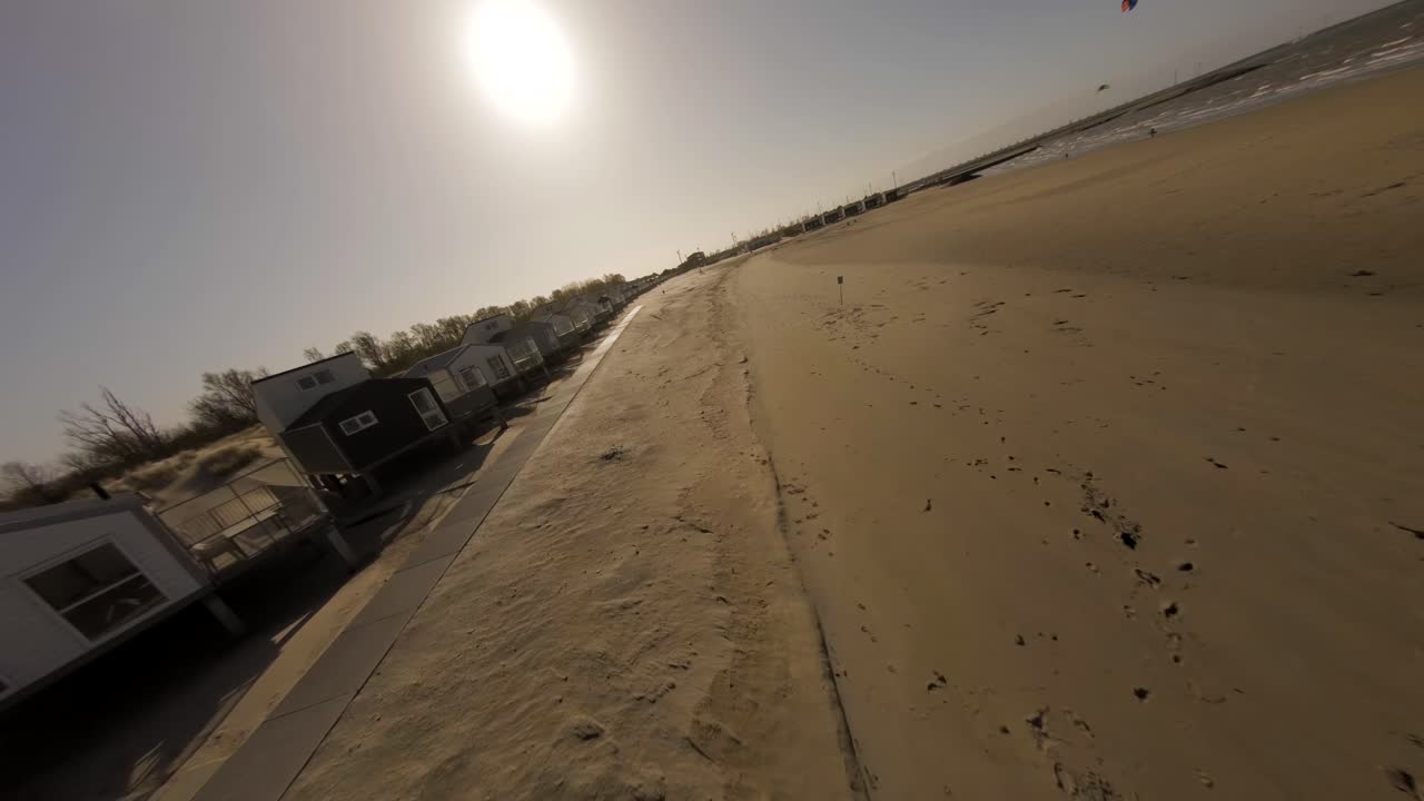 Aerial drone shot of kite surfers playing in ocean by golden Roompot beach