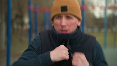 close-up of a focused coach working out quickly, with a blurred view of a car's headlights and red and blue iron bars in the background