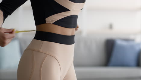 woman measuring waist with tape measure